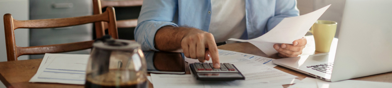 Man sitting at a table using a calculator