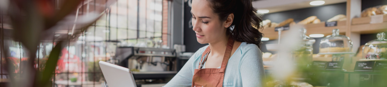 Woman looking at a tablet in a cafe