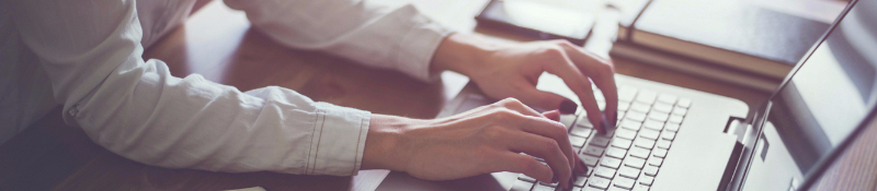 Hands typing on a keyboard. 